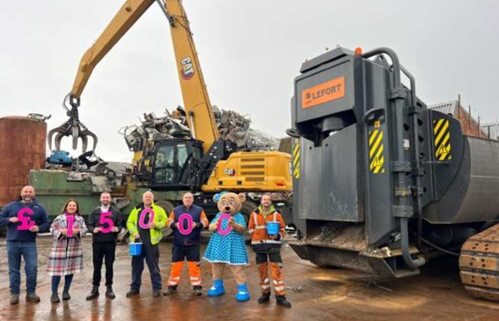 Team from Murphy Scrap Metal hold up figures showing fundraising figure